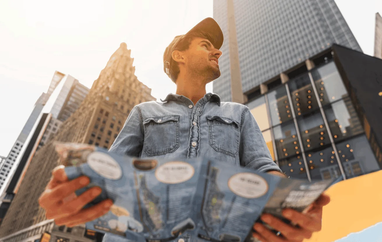 Young man exploring the cityscape, holding a map in hand