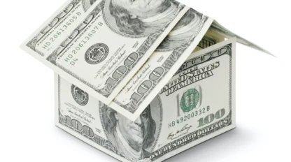 A house constructed from folded U.S. one hundred dollar bills, symbolizing the concept of money and real estate.